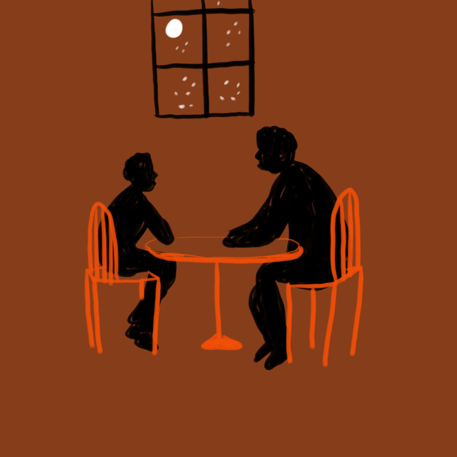 two people, one older and one younger, sit facing each other at a table with a window in the background