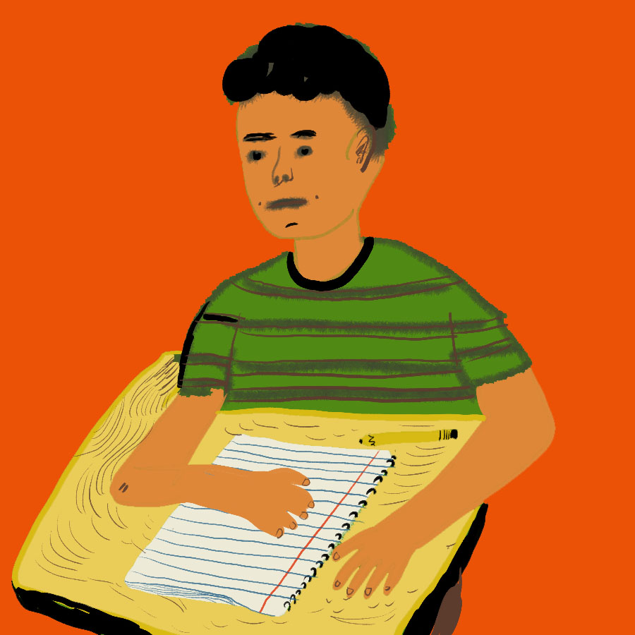 young boy of color sitting at a desk with an open notebook on it